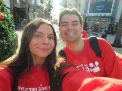 两名身穿红色t恤的学生在自拍风格的照片中微笑.